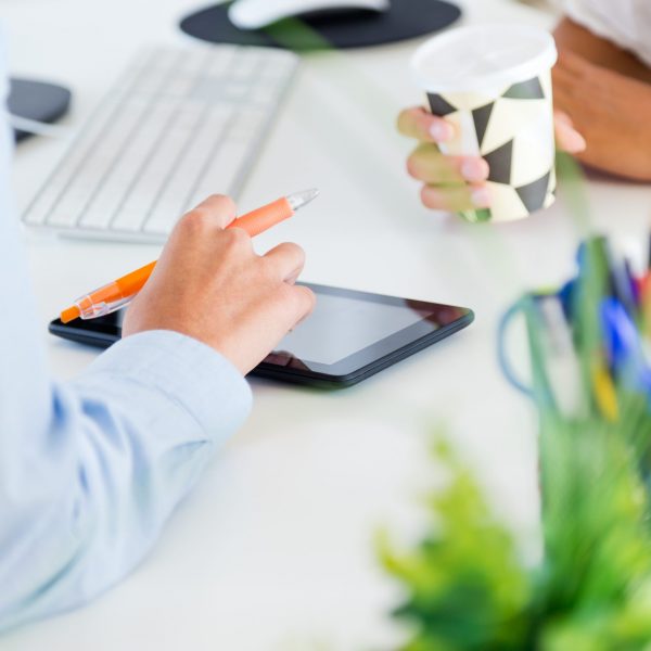 Portrait of two business woman working in office with digital tablet.